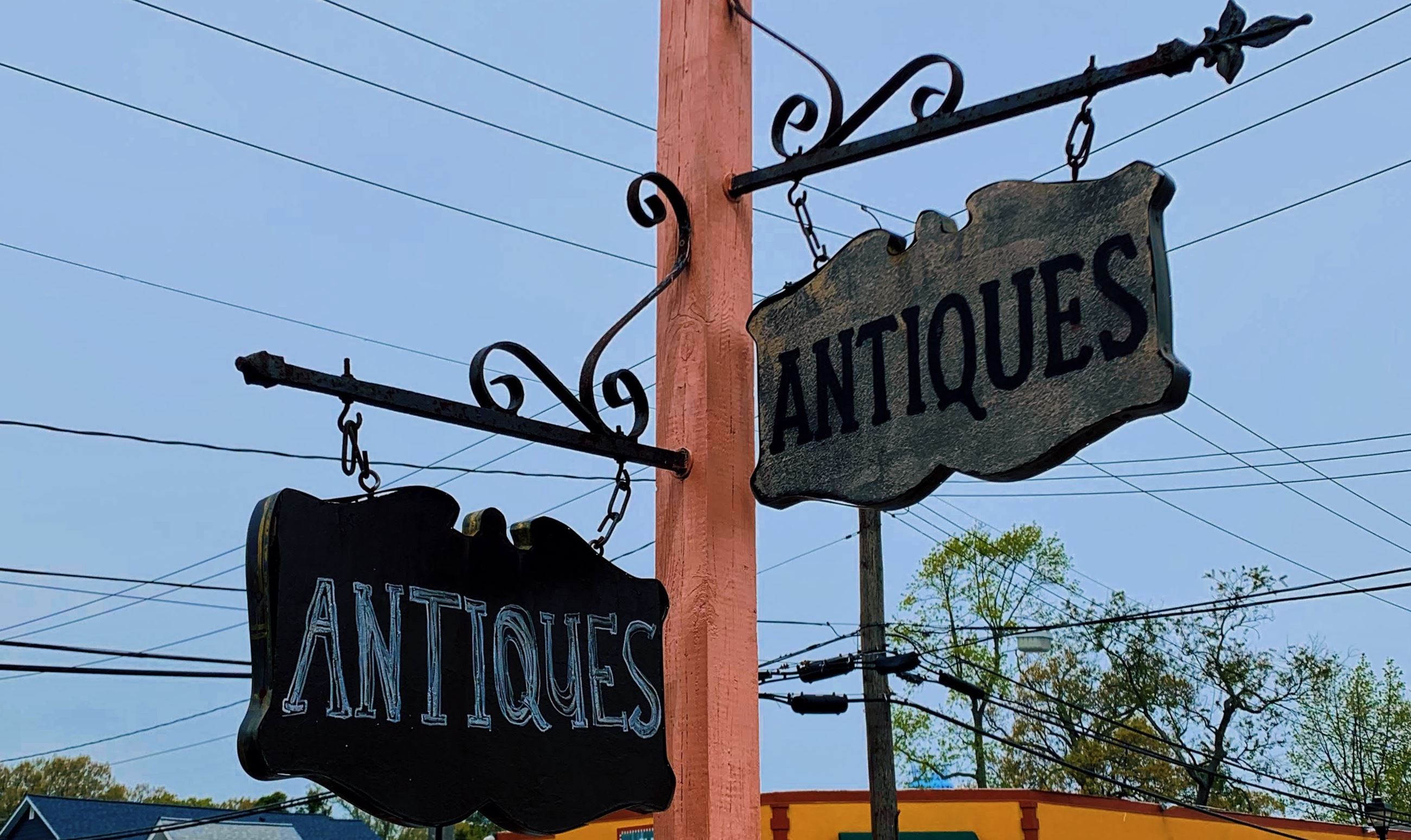 Two signs that both say "Antiques" pointing in two different directions in North Beach