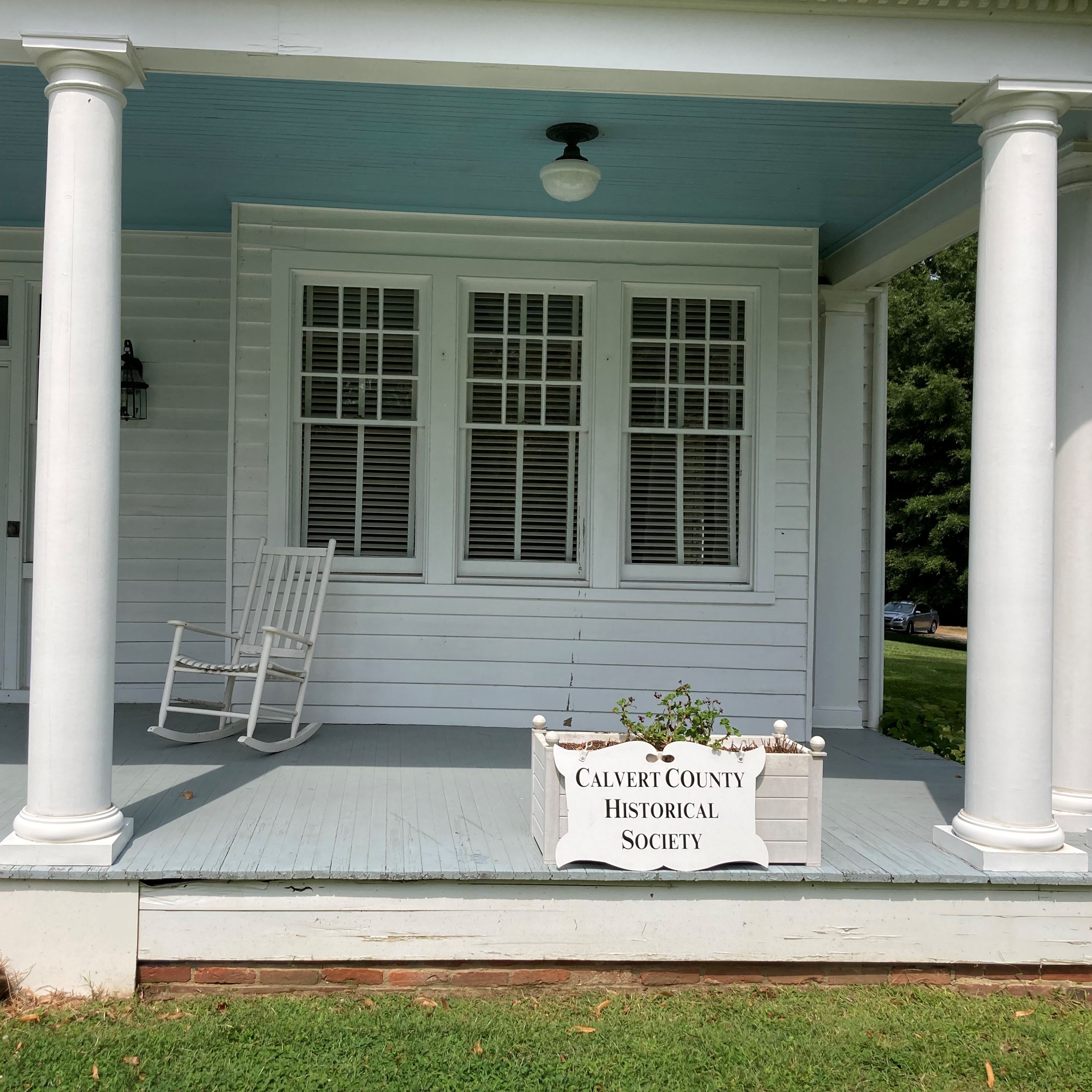 Sign that says Calvert County Historical Society in front of an old white house with pillars