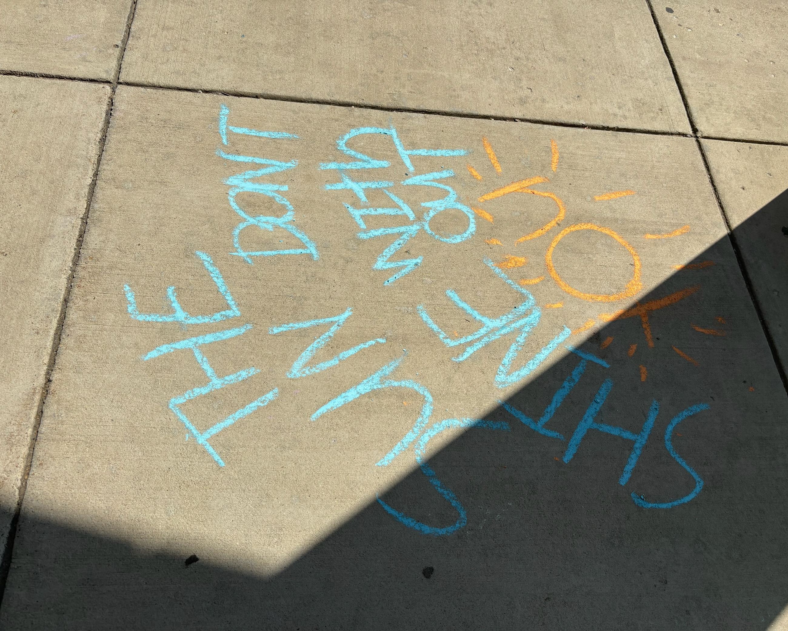 Blue and yellow sidewalk chalk art of stars with text "He made you fearfully and wonderfully."
